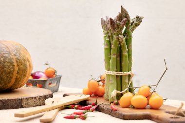 Masadaki taze sebzeler. Balkabağı, kuşkonmaz, portakal domatesleri, acı biberli kompozisyon.