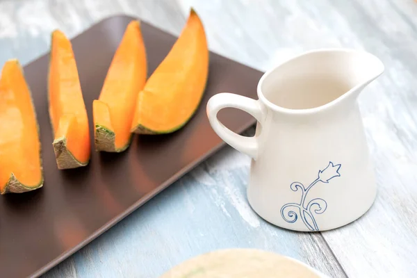 Sliced orange melon on a wooden table — Stock Photo, Image
