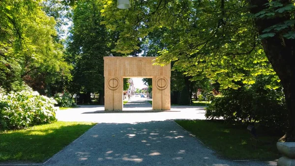 Targu Jiu, RO - 20 Haziran 2020: Constantin Brancusi Heykel Topluluğundan Öpücük Kapısı. Birinci Dünya Savaşı 'nın Romen kahramanlarına hürmet. UNESCO miras sitesinin renkli yaz manzarası. Doğu Avrupa 'da kültürel seyahat merkezi.