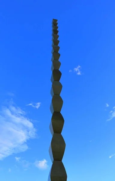 Targu Jiu, ROMANIA - 31 Ekim 2020: Sonsuz Sütun (Coloana Infinitului) Constantin Brancusi Heykel Topluluğundan. Mavi gökyüzü arkaplanlı orijinal görünüm. Gökyüzüne uzanan bir anıt. Sonsuzluk sembolüne yükseliş. UNESCO Anıtı.