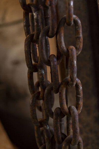 rusty chain hanging in a barn, heavy chain, large, old chain,iron rusty chain