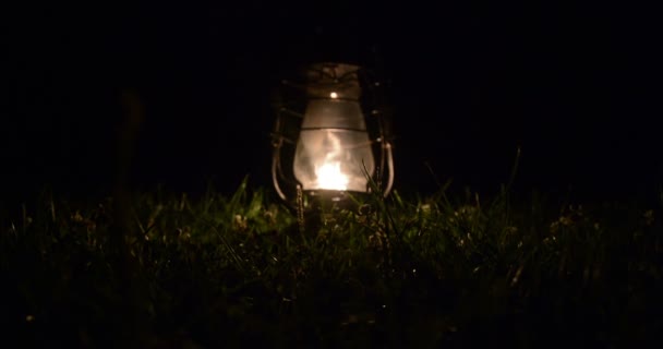 밤에 잔디에 오래 된 등유 램프. — 비디오