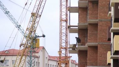 İnşaat. Bina. Vinç. Balkon üzerinde çalışan.