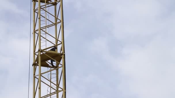 Construction. Man climbs up on crane. — Stock Video