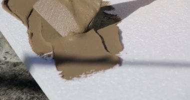 İnşaat. Adam harç strafor uğratan. Yakın çekim.