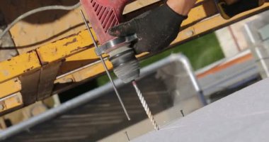 İnşaat. Adam matkaplar duvar perforator ile.