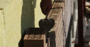 İnşaat. Adam tuğla bırakır.