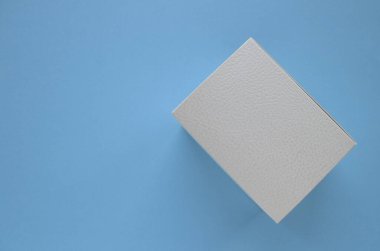 Mavi arka planda beyaz hediye kutusu.                             