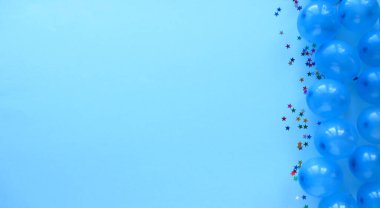 Açık mavi arka planda mavi hava topları. Mesaj için yer. Tatillerde. Topların yanında küçük yıldızlar. Yerleşim planı. Yukarıdan görüntüle.      