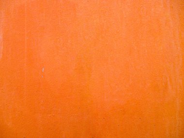 Turuncu renkli eski bir duvarın arka planı. Doku çatlaklarla ve çiziklerle aynı renkte değil. Pembe bir boya tabakasının altında görünür.. 