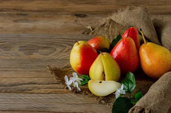 Ripe pears fruit. Harvested organic pear on burlap on wooden table. Autumn harvest