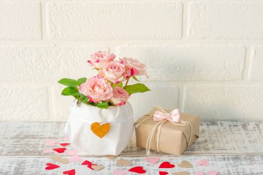 Tatiller için kutlama kartı. Güzel bir buket pembe gül ve ahşap arka planda hediye kutusu