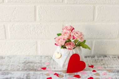 Güzel bir buket pembe gül ve kırmızı kalpler. Düğün ya da Sevgililer Günü için aşk kompozisyonu.