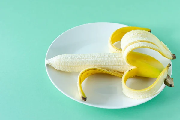 青い背景のプレートの上においしいバナナを熟す 健康食の概念 — ストック写真