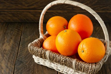 Tahta arka planda yeşil yapraklı taze sulu portakallar.