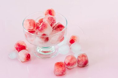 Pembe arka planda çilekli buz küpleri