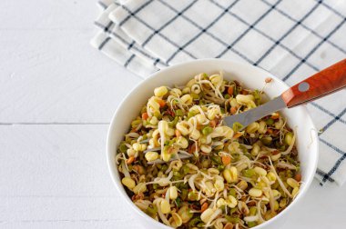 Beyaz masada bir kasede fasulye filizlendirdim. Sağlıklı konsept, makrobiyotik gıda