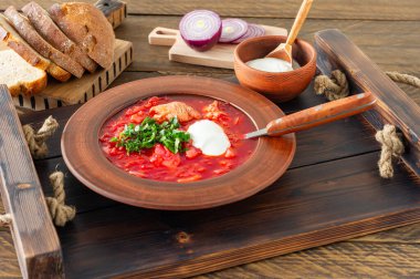 Borsch - geleneksel Ukrayna ve Rus pancar çorbası koyu ahşap arka planda. Çavdar ekmeği, sarımsak ve ahşap tepside tuz ile servis edilir..