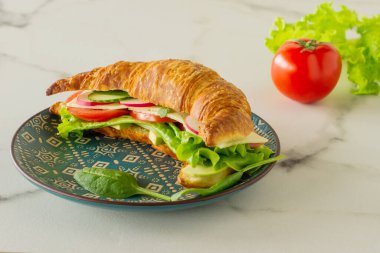 Somon, marul ve salatalıklı çıtır kruvasan. Lezzetli kahvaltı..