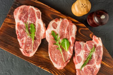 Baharatlı Raw Pork Neck, Olgun Domatesler ve Tahta Kesme Tahtasındaki Taze Yapraklar. Üst Görünüm.