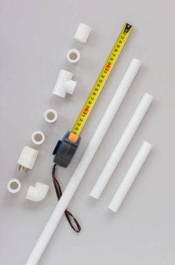 Su sistemi için plastik borular, gri arka planda cetvel ve ölçüm seviyesi. Onarım, satış, online. Düz yatıyordu. Boşluğu kopyala