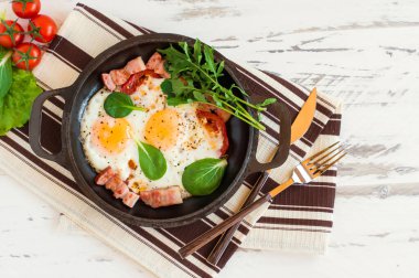 Kahvaltıda ya da öğle yemeğinde kızarmış yumurta, ıspanak, roka, domates ve domuz pastırması.