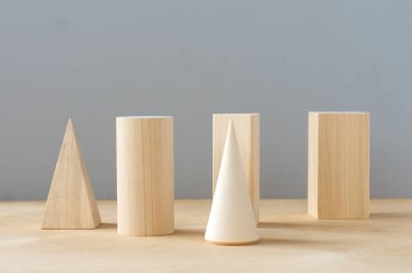 Gri arkaplanda, kopyalama alanı olan tahta geometrik şekiller. anaokulu öğrenimi.