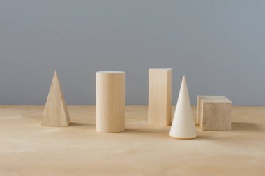 Gri arkaplanda, kopyalama alanı olan tahta geometrik şekiller. anaokulu öğrenimi.
