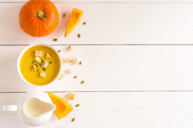 Hindistan cevizi sütü üzerine olgun balkabağı çorbası. Çorbalı kase. Portakal kabağı. Sütlü sütçü. Üst Manzara. Beyaz arkaplanda metin için bir yer