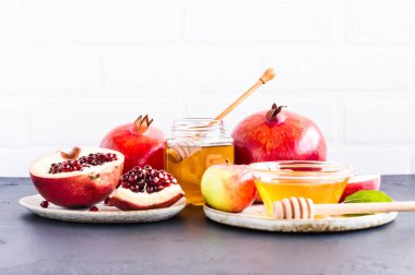 Beyaz arka planda elma, nar ve bal var. Yahudi bayramı Rosh Hashanah.