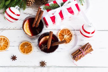 İki bardak sıcak şarap süslü baharatlar ve kuru portakallar. Noel tatili için kutlama kartı, üst manzara..