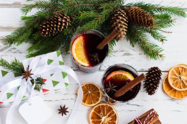 Kuru portakallı kırmızı şarap ve kozalaklı köknar ağacı dallarının üst görüntüsü. Noel içeceği, en iyi manzara..