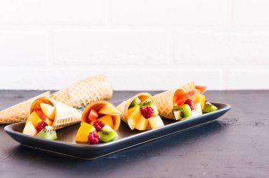 Elma, kivi, portakal, waffle külahında üzüm. Sağlıklı yiyecek.