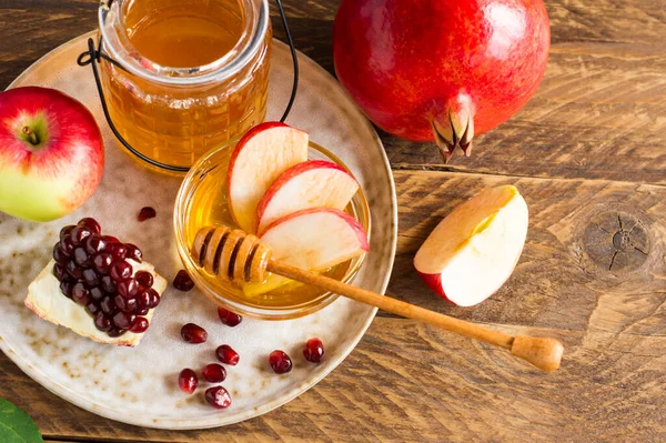 Pomegranate, apple and honey, traditional food of jewish New Year celebration, Rosh Hashana