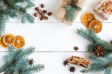 Yeni yıl arkaplanı, ladin dalları, fındık, tarçın çubukları, portakal dilimleri, tatil kutuları. boşluğun bir kopyası