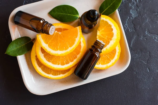Ätherisches Aromatisches Orangenöl Mit Zitrusfrüchten Auf Einem Keramikteller Und Schwarzem — Stockfoto