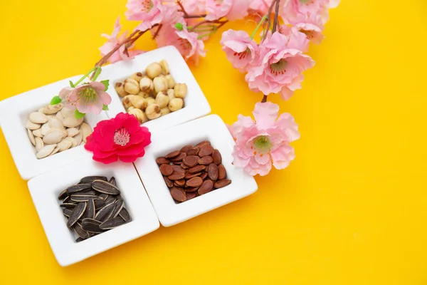 Tet Holiday, Ay yeni yılı, Çin yeni yılı konsepti. Kurumuş ayçiçeği, nilüfer, karpuz ve kabak çekirdekleri sarı üzerine izole edilmiş.