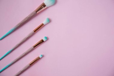 Pembe üzerine izole edilmiş makyaj fırçaları. Düz yatıyordu.