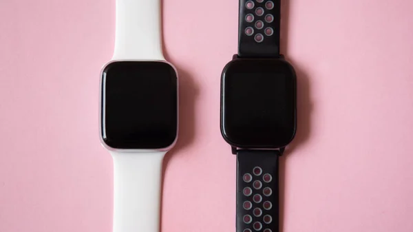 black and white smart watch top view isolated on pink background