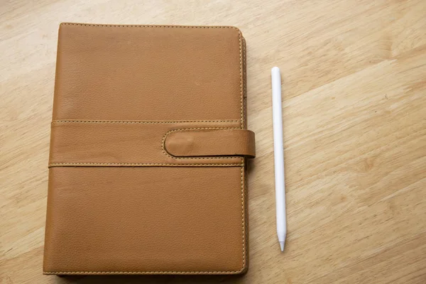 Bovenaanzicht Van Bruin Leren Notitieboekje Met Pen Houten Tafel — Stockfoto