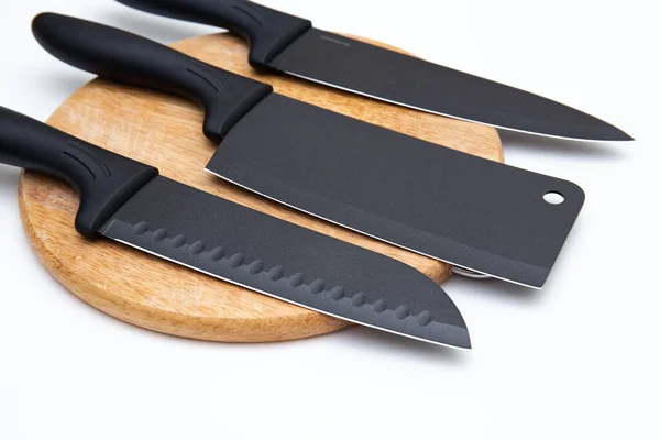 Lüks siyah mutfak bıçağı beyaz üzerine izole edilmiş kesim tahtasının üzerinde.