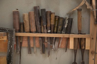 Bir atölyede odun oymak için keski ve el aletleriyle dolu bir raf. 