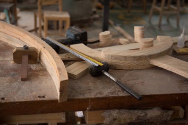 Marangoz aleti ve ürünü atölyedeki bir masanın üzerinde. Çekiç, cetvel, matkap