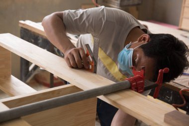 Yakın plan el marangozu ahşap kalasları bir açıyla birleştiriyor. Atölyede çalışan bir adam. Ahşap mobilyaların yapımı ve yenilenmesi üzerine doğrama işleri. Küçük İş Konsepti