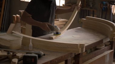 Kum makinesi, marangoz ahşabı pürüzsüz hale getirmek için bir cilalama makinesi kullanır..