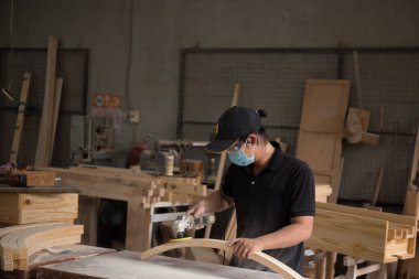 Kum makinesi, marangoz ahşabı pürüzsüz hale getirmek için bir cilalama makinesi kullanır..