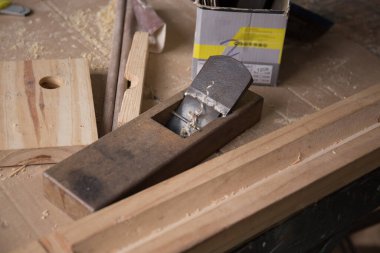 Atölyedeki diğer detaylarla birlikte bir marangoz uçağının yakın çekimi.