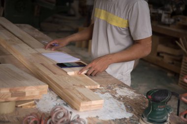 Marangozun elini kapat ve müşterinin yeni siparişlerini kontrol etmek için akıllı telefon kullan. 