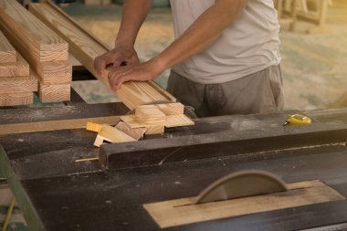 Testereyle odun kesen genç bir işçi.