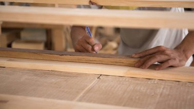 Marangoz atölyede cetvelle ahşap tahtayı ölçüyor. Ahşap mobilya üretiminde doğrama işi. Küçük İş Konsepti